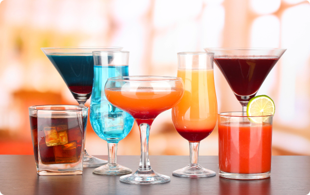 Kolorowe drinki w r&oacute;żnych kieliszkach i szklankach