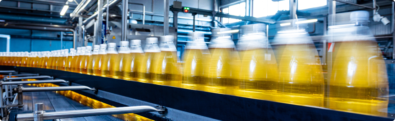 Taśma produkcyjna z butelkami napełnionymi sokiem